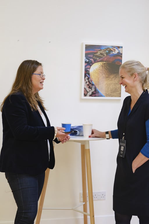Two participants laughing mid-conversation at a Sonas Method event