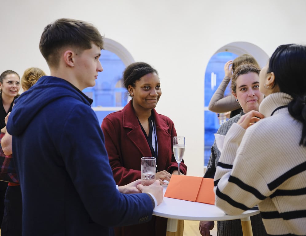 Participants talking in a small group at a networking event